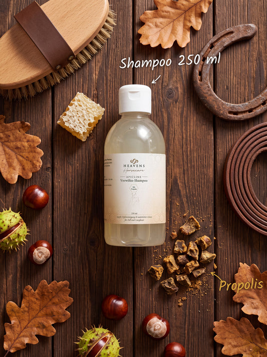 Heavens Horsecare Verwöhn-Shampoo 250 ml mit Propolis in der Flasche, auf dunklem Holz neben Pferdebürste, Hufeisen und Lederstrick, dazu Rohpropolis, eine Wabe, Kastanien und Eichenlaub