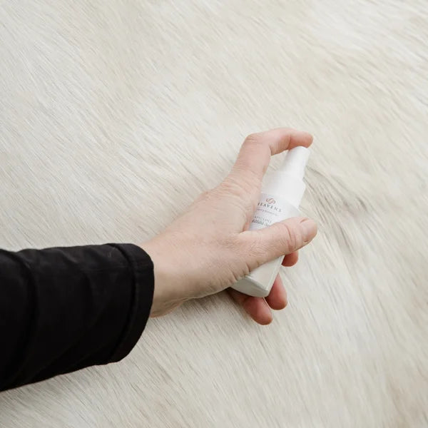 Eine Hand sprüht das Propolis Wohlfühl-Spray auf weißes Pferdefell